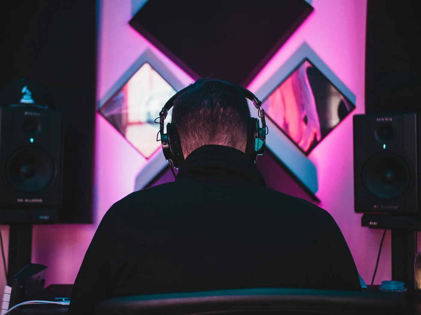 Music producer wearing headphones between studio speakers